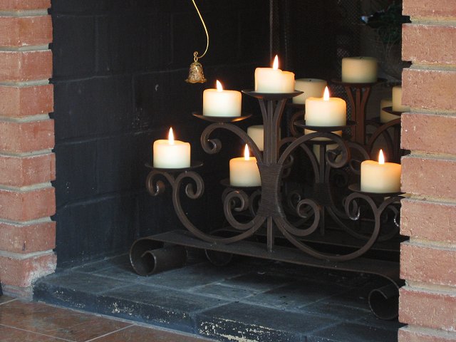 Candles burning in fireplace